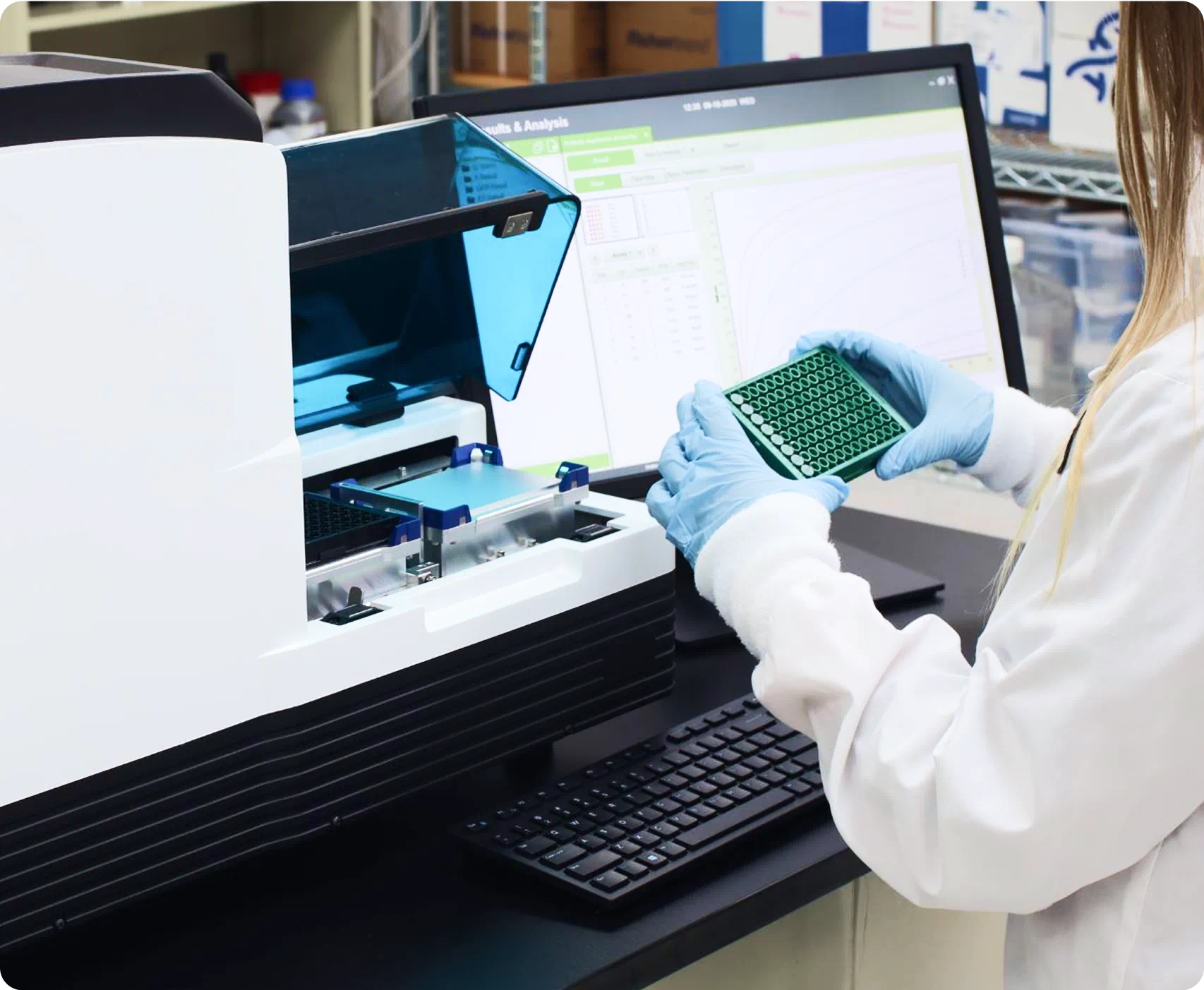 a scientist stands in front of our instrument with a tray of test tubes